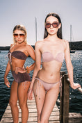 Load image into Gallery viewer, Model wearing Ataya Reversible Tie Side Pant in Dusty Lilac / Espresso  on a Jetty with water behind
